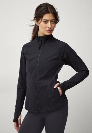 Black athletic jacket with a high collar, zip front, and fitted design. Features thumbholes at the cuffs and two side pockets.