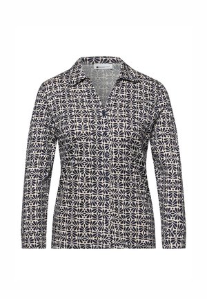 Chemise à manches longues avec boutons, motif floral abstrait en noir et blanc, et col pointu.