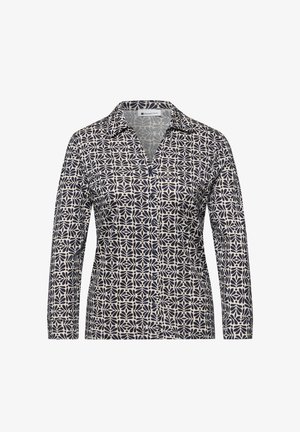 Camisa de manga larga con botones, con patrón floral abstracto en blanco y negro y cuello puntiagudo.