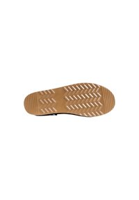 Suela de zapato negra con una superficie de goma texturizada, que presenta un patrón de dibujo en zigzag y una entresuela color marrón claro para mayor tracción.
