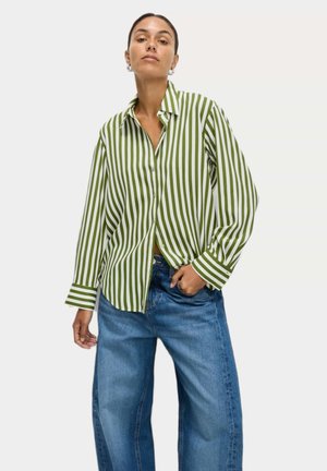 Green and white striped button-up shirt with a collar, long sleeves, and a relaxed fit, paired with blue wide-leg jeans.