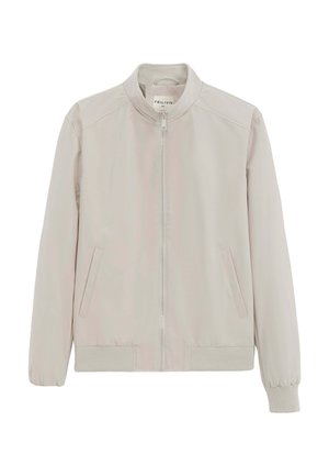 Veste beige clair zippée avec poignets et ourlet côtelés, col montant et poches latérales inclinées.