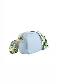 Borsa a tracolla in pelle azzurro chiaro con una zipper dorata, tracolla floreale e dettagli hardware geometrici. Forma rettangolare compatta, texture liscia.