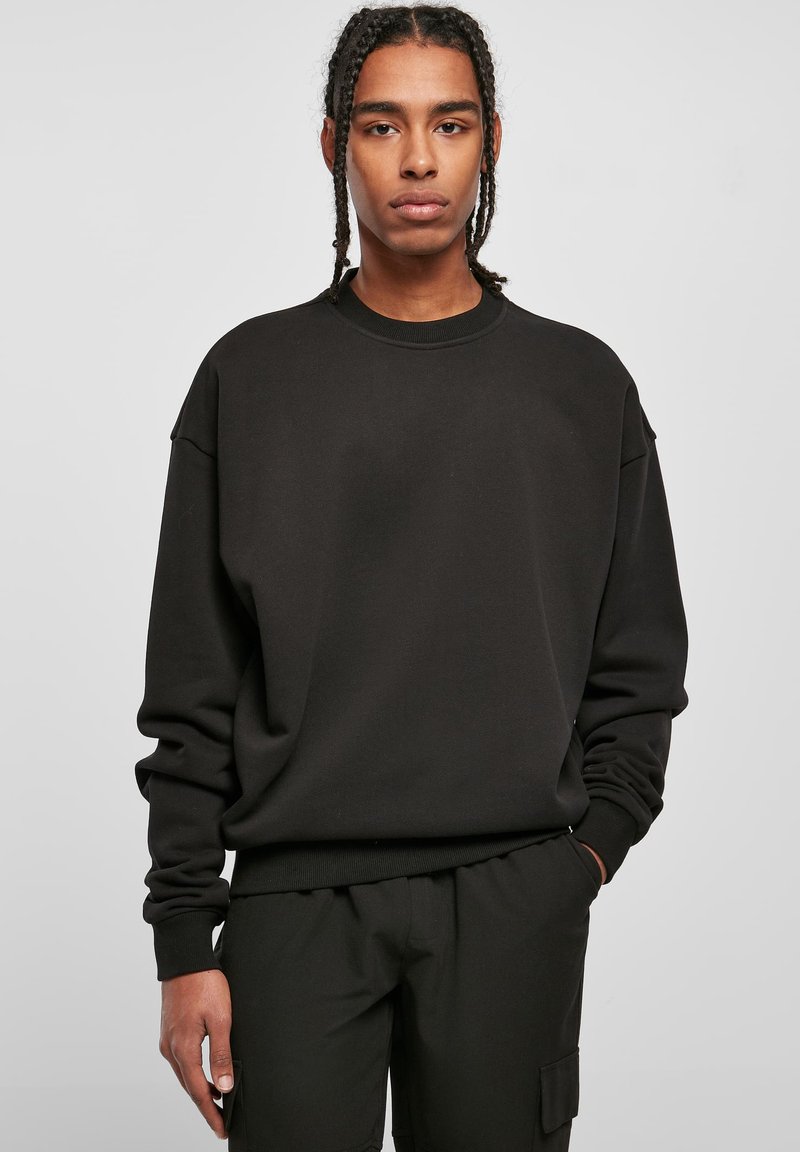 Felpa nera con maniche lunghe, collo rotondo e vestibilità rilassata. Realizzata in un tessuto morbido con una texture liscia e un design minimal.
