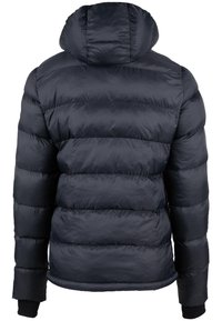 Tume sinine puhvjakott kapuutsiga, quiltitud disainiga ja elastsete kraedega. Sile tekstuur nähtavate õmblustega ja ümar kaelus.