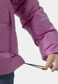 Růžová prošívaná bunda s lesklou texturou. Obsahuje kapsu na zip a nastavitelný šňůrkový lem. Reflexní detaily na rukávu.