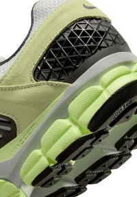 Nike löparsko med ovandel i mesh och mocka i ljusgrönt, texturerade svarta detaljer och en tjock neongrön sula med mönstrat mönster.