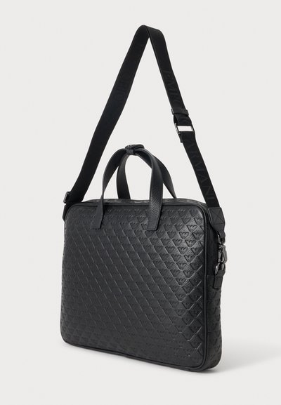 Sacoche pour ordinateur portable en cuir noir avec motif triangulaire embossé et bandoulière réglable avec le nom de la marque.