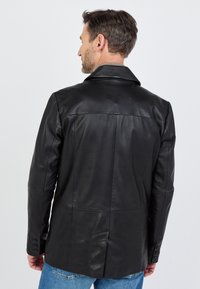 Czarna skórzana kurtka o dopasowanym kroju, z klapowym kołnierzem i zapinanymi mankietami, pokazana z tyłu, z gładkimi detalami tekstury.
