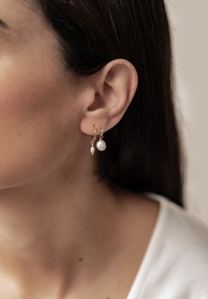 Goldene Creolen mit zwei Anhängern: eine kleine Perle und eine tropfenförmige Perle. Das Design beinhaltet subtile Akzente für Eleganz.