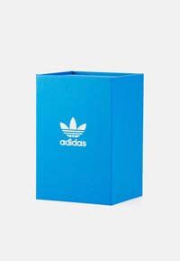 Plava kartonska kutija s bijelim Adidas logom i tri listasto oblikovana akcenta, pravokutnog oblika, glatke teksture i bez vidljivih dijelova.