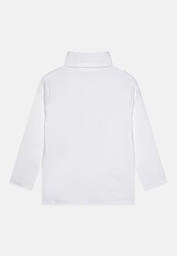 Polo shirt bianca a maniche lunghe con colletto alto, tessuto morbido e senza motivi o hardware visibili. Design semplice e minimalista.