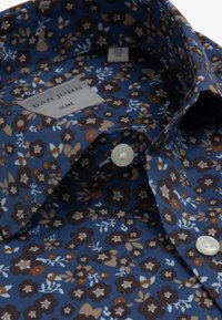 Sininen slim-fit-paita, jossa on ruskea ja beige kukkakuosi, valkoiset napit ja "Dan John" -labeli kauluksessa.