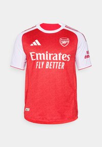Rood en wit Arsenal voetbalshirt met korte mouwen, voorzien van een gestructureerd patroon, het logo "Emirates Fly Better" en Adidas strepen.