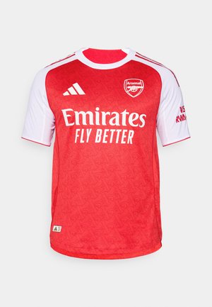 Sarkans un balts Arsenal futbola krekls ar īsām piedurknēm, ar teksturētu rakstu, "Emirates Fly Better" logo un Adidas svītrām.