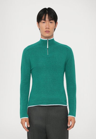 Pullover de manga longa em turquesa com fecho, com colarinho alto, apresentando uma bainha em azul claro contrastante e tecido de malha texturizada.