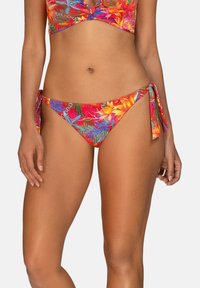 Kostium kąpielowy w żywe kwiatowe wzory z wiązanym dołem na boku. Zawiera mieszankę czerwieni, pomarańczy i zieleni, gładką tkaninę oraz krótki top.