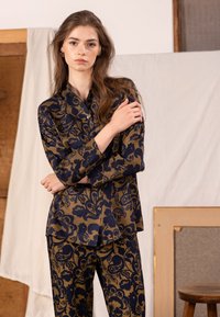 Navy blue and gold floral-patterned shirt and pants set, made of smooth fabric, featuring a button-down front and long sleeves.