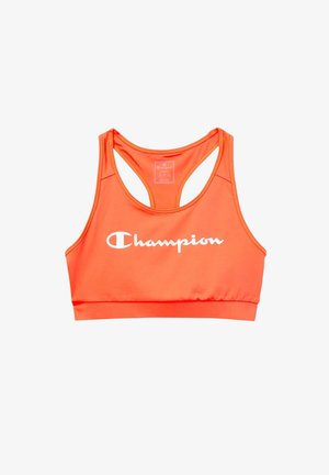 Orange sports bra made of stretchy fabric, featuring a racerback design and a white Champion logo on the front. Smooth texture, minimal detailing.