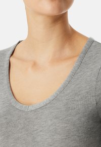 Grijze v-hals t-shirt met korte mouwen, gemaakt van een zachte, gestructureerde stof en met een reguliere pasvorm. Zichtbare stiksels langs de halslijn en schouders.