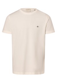 Cremefarvet bomulds T-shirt med korte ærmer, rund hals og et lille broderet logo på brystet. Glat tekstur, minimal design.