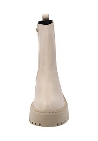 Botas de tobillo beige con un acabado de cuero suave, cremallera lateral, un tirador y una suela gruesa y resistente con ranuras horizontales.