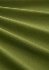 Olivegrüner Stoff mit weicher Textur, der glatte Falten und ein gleichmäßiges Oberflächenmuster zeigt und ein mattes Finish hat.