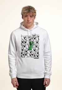 Felpa bianca con cappuccio caratterizzata da un design pixelato di "Minecraft" con numerosi volti di Creeper in bianco e nero, e un elemento centrale verde a forma di Creeper.