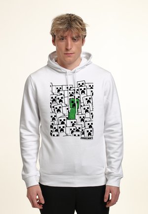 Felpa bianca con cappuccio caratterizzata da un design pixelato di "Minecraft" con numerosi volti di Creeper in bianco e nero, e un elemento centrale verde a forma di Creeper.