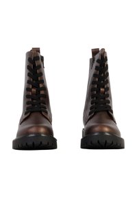 Paire de bottes en cuir marron à lacets avec semelles noires, fermetures éclair latérales et passants, vues de face sur un fond blanc.