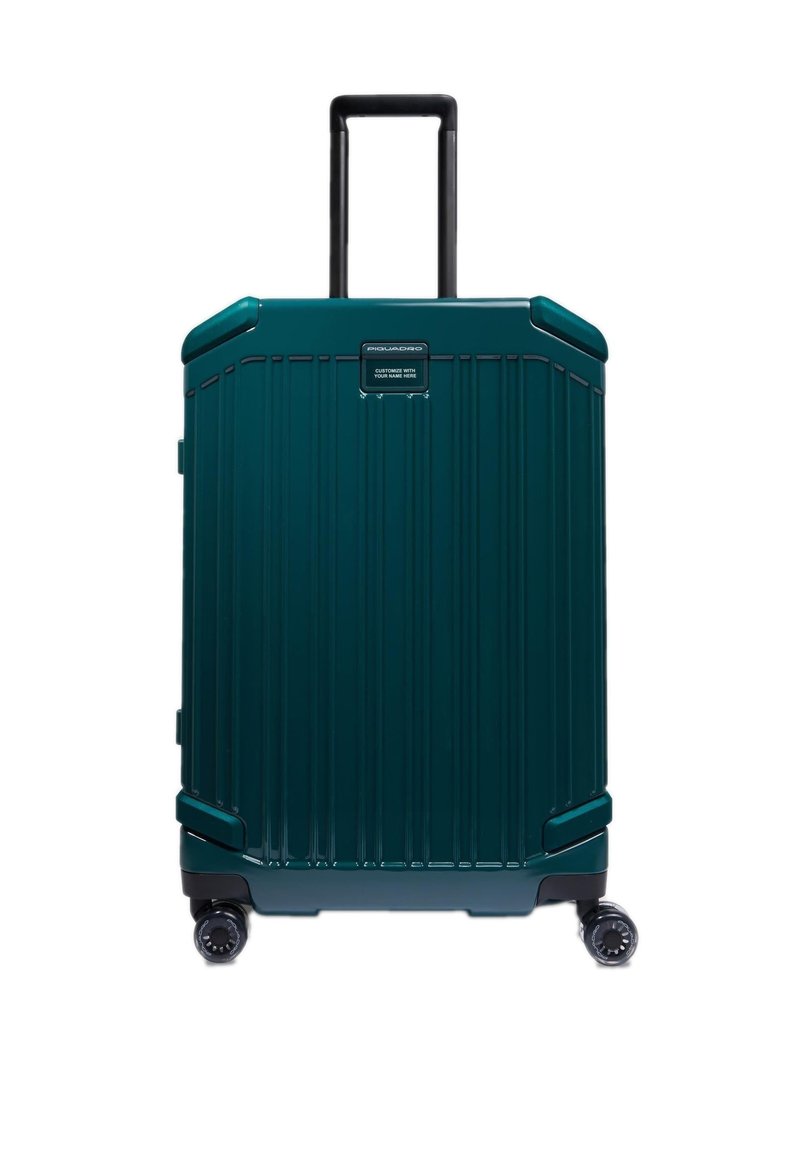 Donker teal harde koffer met verticale groeven, uittrekbare zwarte handgreep en vier wielen voor mobiliteit. Voorzien van een aanpasbare naamplaat.