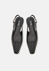 Schwarze Slingback-Schuhe mit eckiger Zehenpartie, ausgestattet mit einem besetzten Design aus silbernen Ösen, glatter Ledertextur und einem silbernen Schnallenakzent.