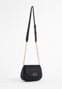 Borsa a tracolla in pelle nera con forma arrotondata, tracolla in catena dorata e un unico clasp decorativo. Superficie strutturata e design snodato.