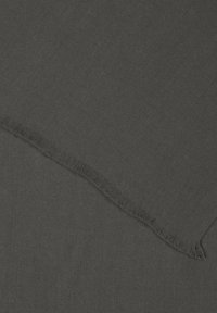 Tissu noir tissé avec une texture douce, présentant des bords frangés. Le matériau est léger et présente une couleur uniforme tout au long.