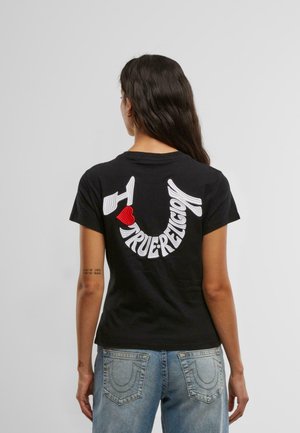Melns kokvilnas T-krekls ar izšūtu "True Religion" logo baltā krāsā, ar sarkanu sirdi kā akcentu. Klasiska aplokšņu kakla forma un īsām piedurknēm.
