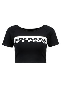 Černý zkrácený sportovní top s krátkými rukávy a bílým vodorovným pruhem, na kterém je výrazný text "IVY PARK" přes hrudník.