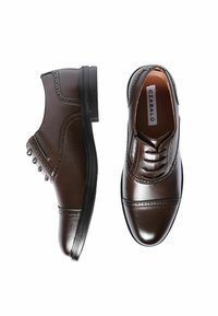 Un paio di eleganti scarpe oxford in pelle marrone lucida con dettagli brogue, una vista di lato e l'altra vista dall'alto su uno sfondo bianco.