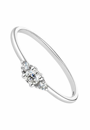 Anillo de metal plateado con un diamante redondo central y dos diamantes redondos más pequeños a cada lado; acabado elegante y pulido.
