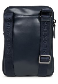 Navy blauwe leren schoudertas met een ritssluiting, verstelbare schouderband met reliëftekst en een eenvoudig rechthoekig ontwerp.