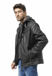 Zwarte leren jas met gewatteerde schouderdetails, ritszakken en een grijze capuchontrui eronder. Heeft een gladde textuur.