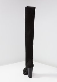 Botas negras de over-the-knee con un ajuste ceñido de punto, acabado texturizado y un tacón grueso para mayor estabilidad.