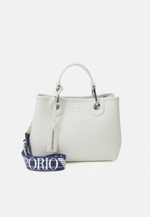 Witte handtas van getextureerd leer met korte handvatten en een afneembare donkerblauwe band met groot wit Emporio-logo.