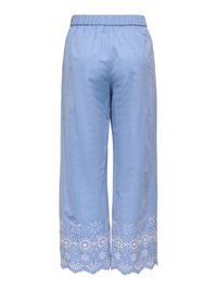 Pantalon large bleu clair avec taille élastique et broderie florale blanche le long des ourlets festonnés.