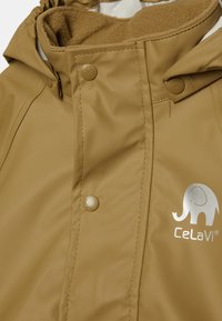 Brun vanntett jakke med en myk fleece-fôret krage, trykknapper og en sølv elefantlogo fra Celavi. Glatt, slitesterkt materiale.