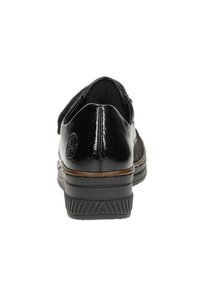 Scarpa in pelle nera con finitura lucida, punta arrotondata e suola textured. Presenta sottili accenti marroni e un logo sul lato.