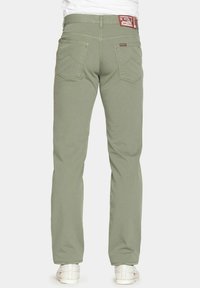 Pantaloni in cotone verde con design a gamba dritta, dotati di due tasche posteriori e di un'etichetta a contrasto sulla vita. Texture liscia.