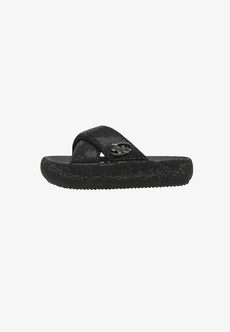 Sandalo nero senza lacci con suola strutturata e ampie fasce incrociate, caratterizzato da un piccolo logo metallico decorativo sul lato.