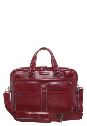 Bordeaux leren tas met dubbele handvatten, afneembare schouderband, twee voorzakken, blauwe accentstiksels en een glanzende afwerking.