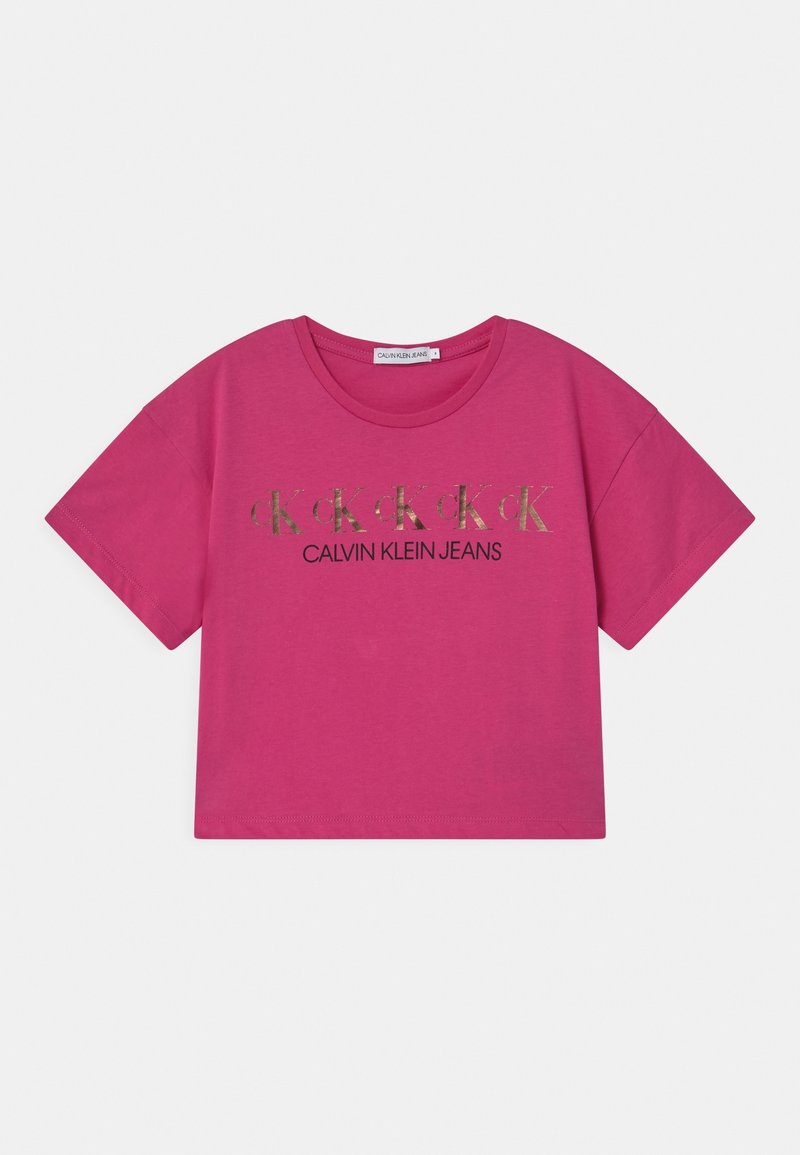 Jaskraworóżowy krótki T-shirt z powtarzającym się złotym logo "CK" oraz czarnym napisem "Calvin Klein Jeans" umieszczonym na środku przodu.