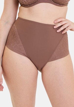 Vrouw draagt hooggetailleerd bruin ondergoed met kanten zijpanelen, bijpassende bruine beha, hand rustend op heup, torso en bovenbenen zichtbaar.